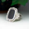 3/4 left view, cushion black onyx gemstone bezel set bead wire and stamped cutout wire accent on tapered wide band